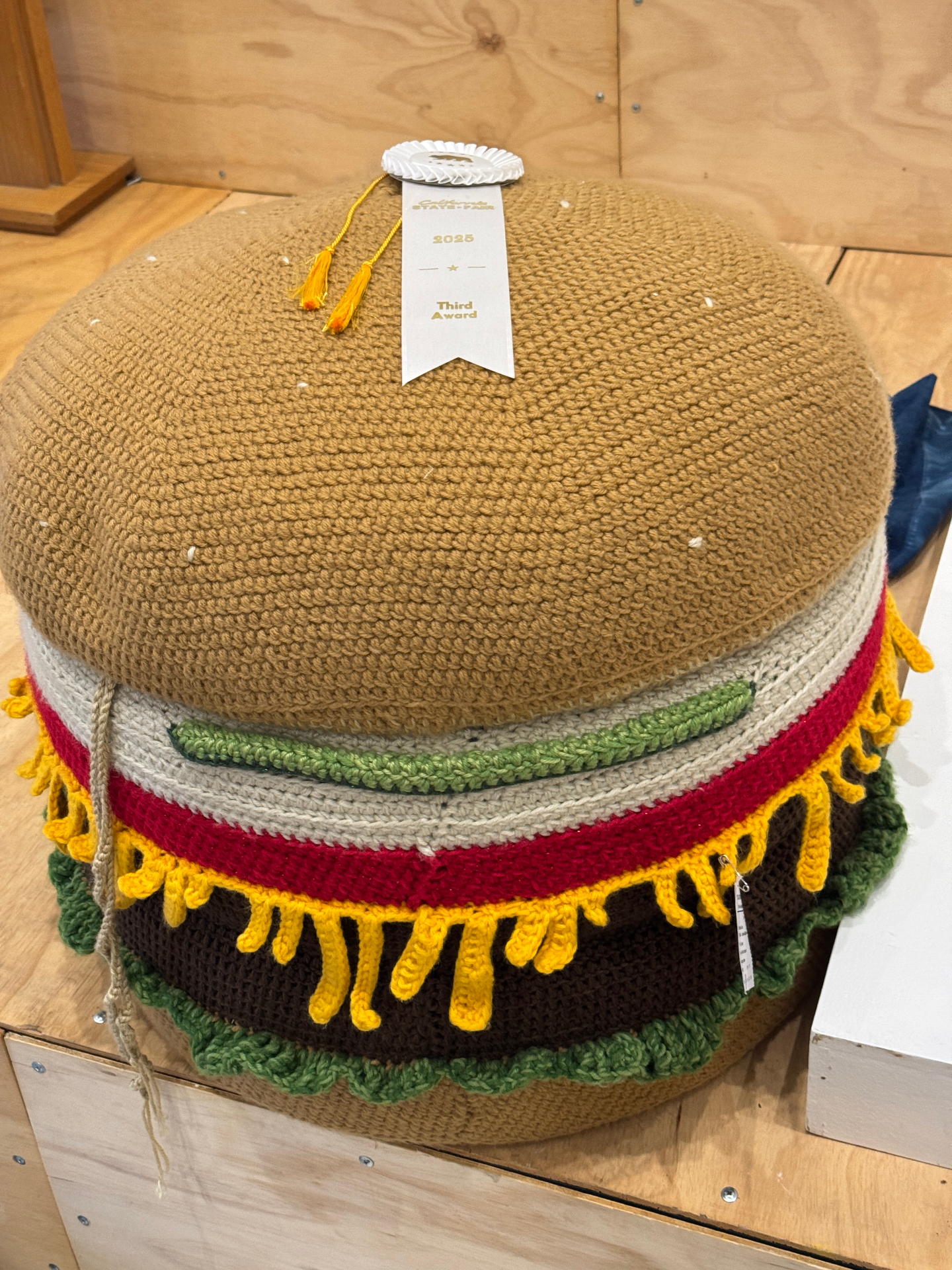 The burger ottoman on display at the California State Fair with a 3rd Place Ribbon, dated 2025.