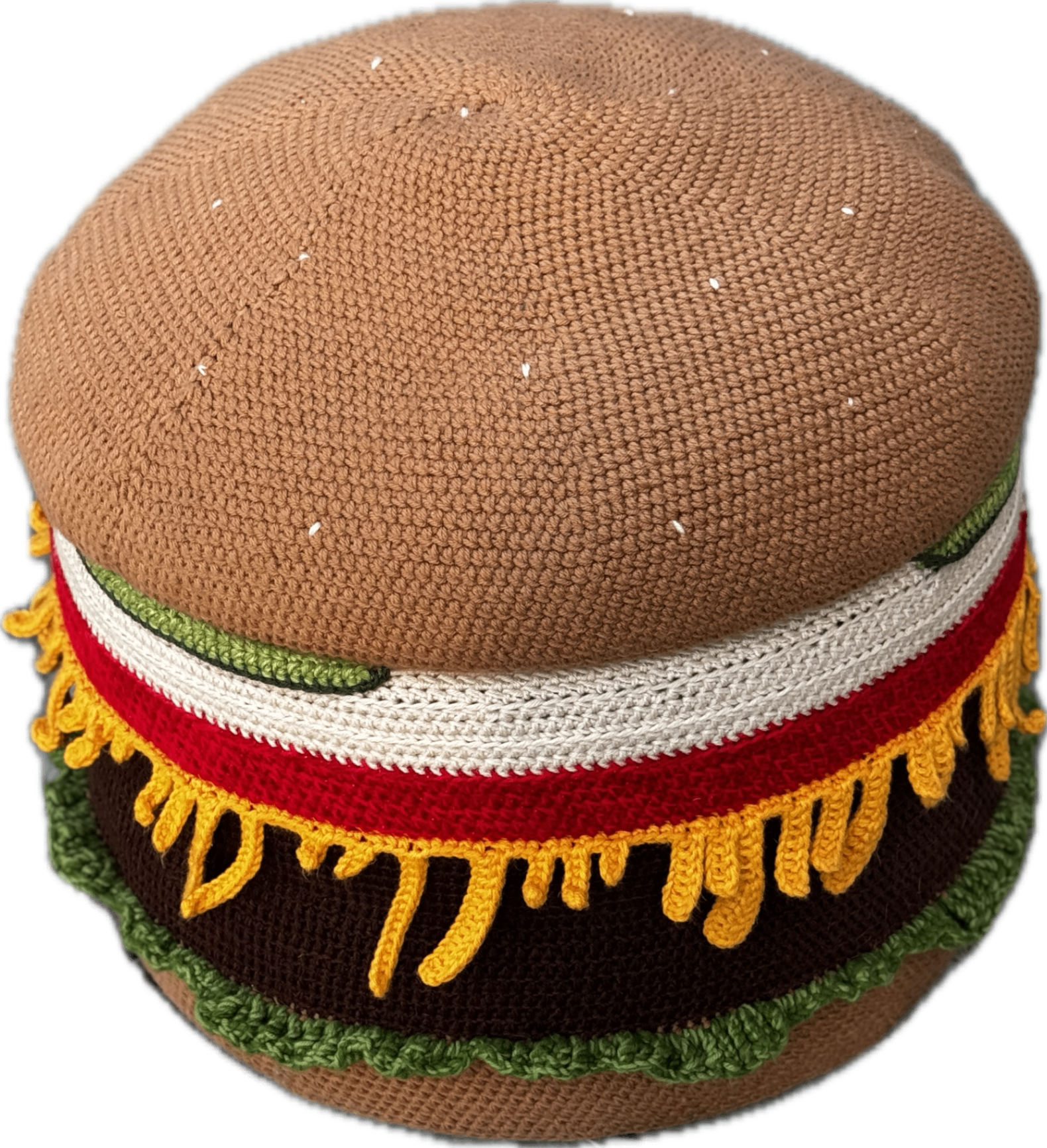 The crocheted burger ottoman photographed straight on against a gray cloth backdrop.