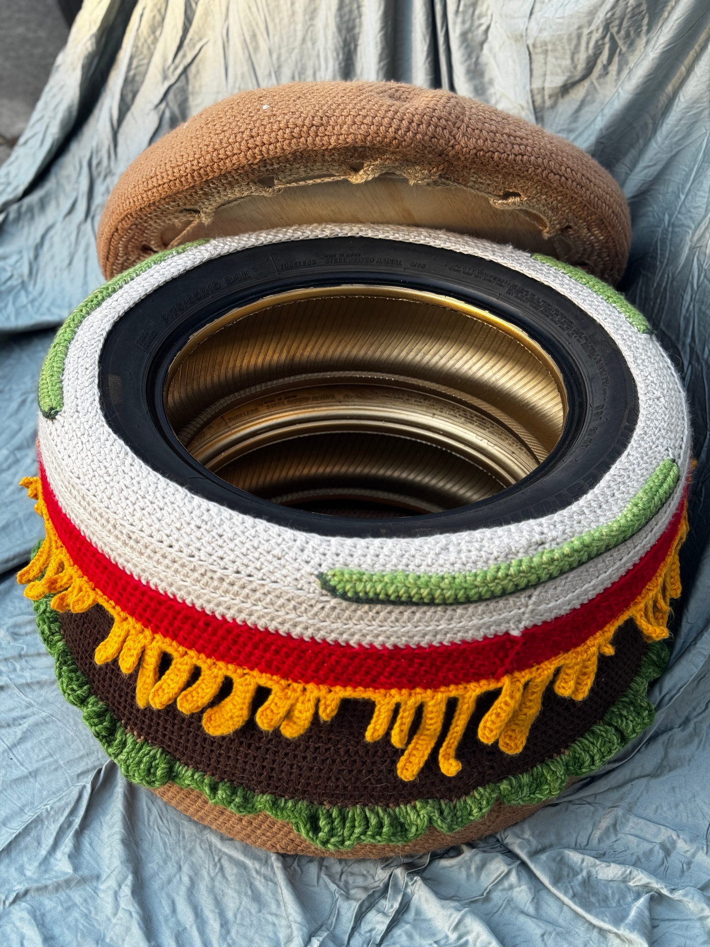 The open burger ottoman next to its removable bun lid.